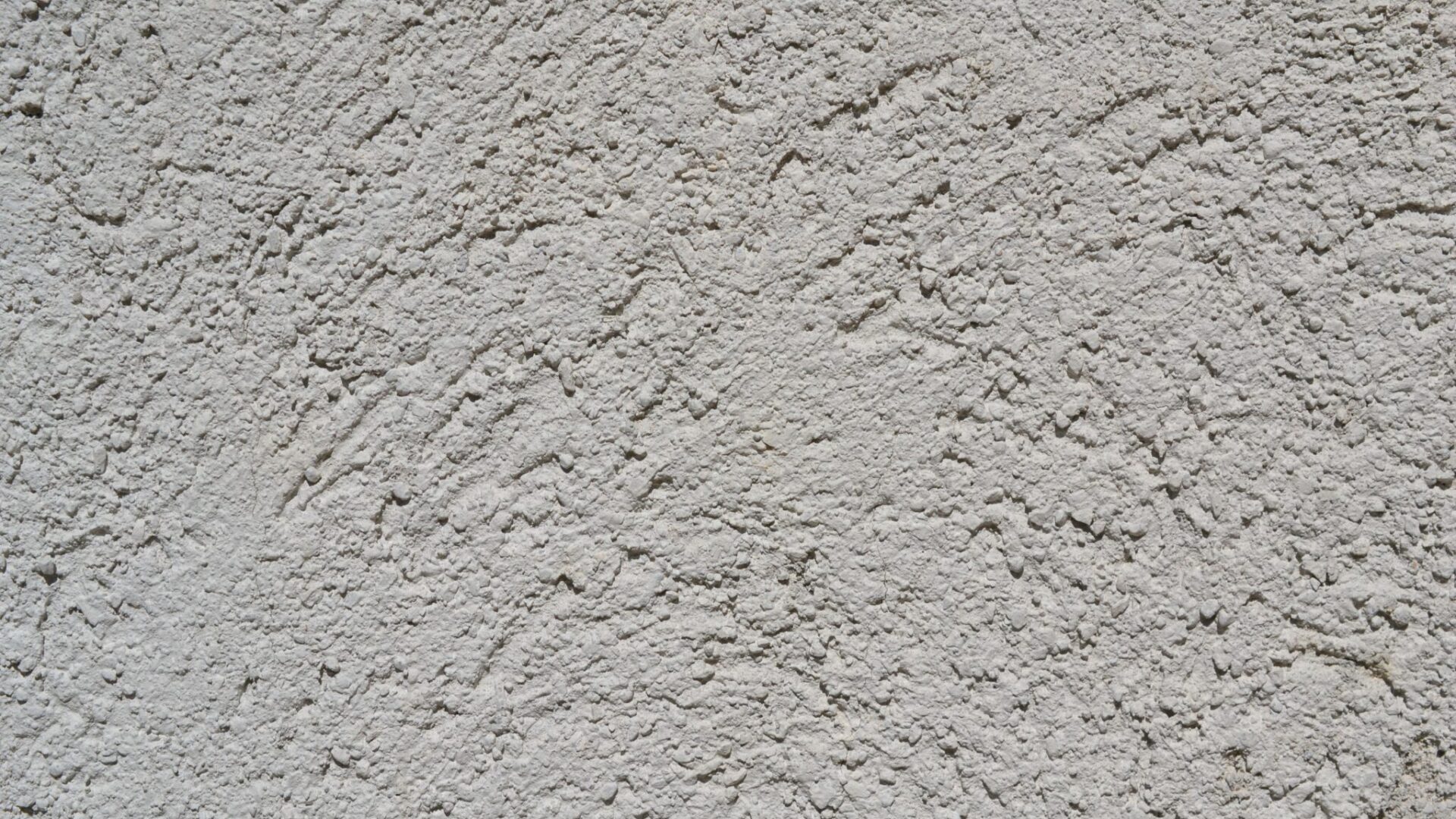 Close-up of a light gray stucco wall texture, ideal for backgrounds.